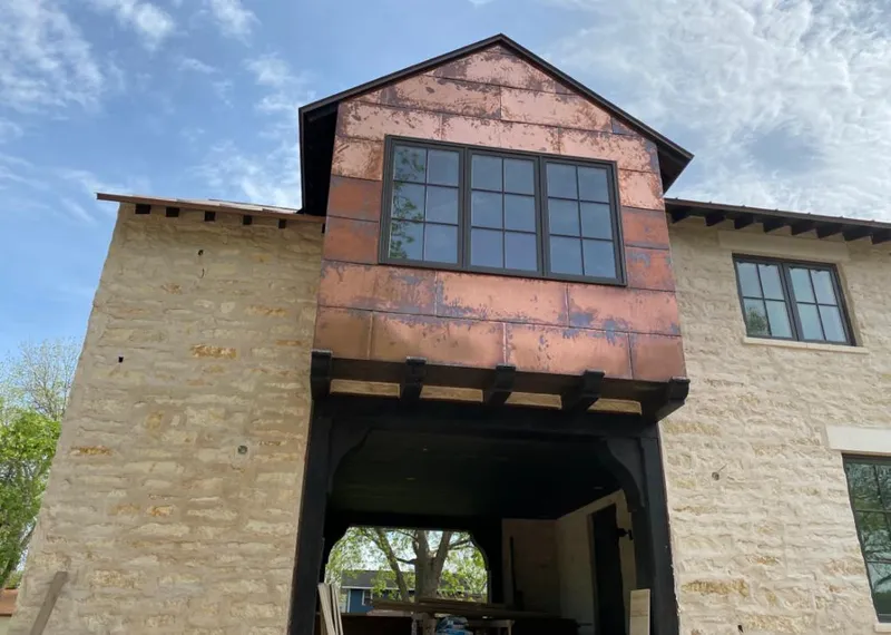 Copper metal panel facade on a stone building for Skylight Installation in Inkster